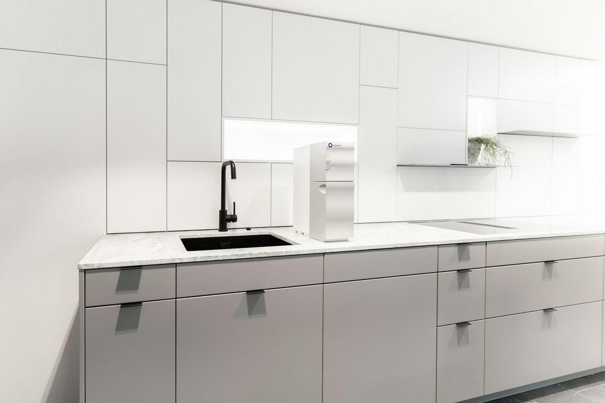 Cocina nórdica reformada con frentes blancos y madera natural
